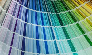 Rozłożona paleta kolorów cmyk, ukazująca szeroką gamę odcieni fioletów, błękitów, turkusów i zieleni, tworząc tęczowy wachlarz.