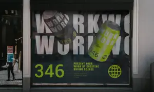 Reklama na witrynie z hasłem "WORK" i puszkami napoju. Folia OWV co to? To materiał na okna, idealny do takich kreatywnych prezentacji.