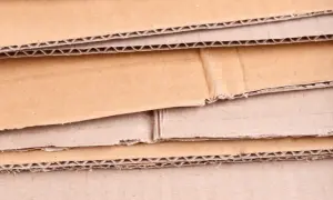 Warstwowa struktura kartonu, ukazująca różne rodzaje tektury falistej i płaskiej, gotowe do recyklingu.
