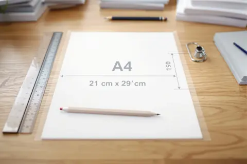 Na biurku leży kartka w formacie **a4** z zaznaczonymi wymiarami, obok linijka i ołówek.