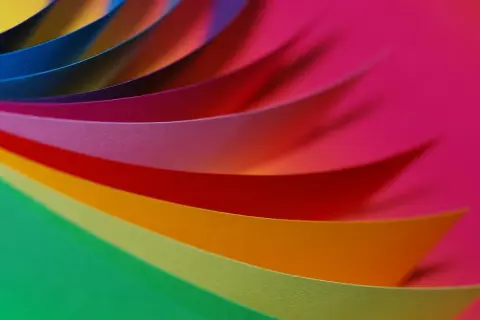 Kolorowe paski papieru układają się w wirującą paletę RGB, tworząc tęczowy wir.