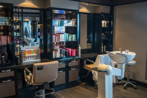 Nowoczesny salon fryzjerski. Reklama usług i produktów Kérastase. Fotele, umywalki i bogaty wybór kosmetyków.