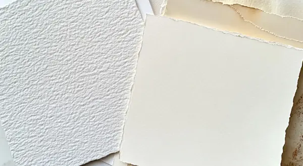 Stos różnych rodzajów papieru, w tym biały, fakturowany papier i kremowy papier o postrzępionych krawędziach. Idealny do sztuki i rękodzieła.