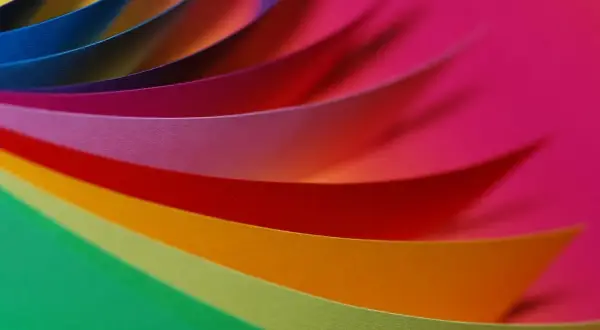 Kolorowe paski papieru układają się w wirującą paletę RGB, tworząc tęczowy wir.
