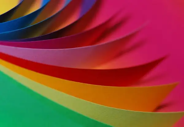 Kolorowe paski papieru układają się w wirującą paletę RGB, tworząc tęczowy wir.